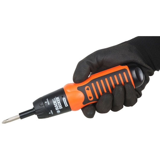 Photo of BLACK+DECKER A7073-IN orange and black cordless screwdriver held in a gloved hand, side angle.