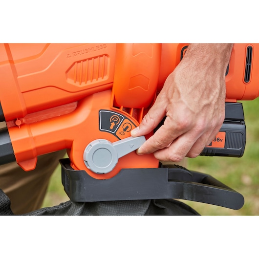 Close-up photo of a BLACK+DECKER BCBLV3625L1 cordless garden blower mode switch with hand adjusting the lever.
