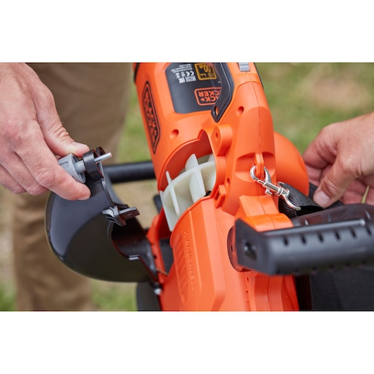 Photo of BLACKDECKER BCBLV3625L1 leaf blower being assembled, showing orange and black housing and handle.