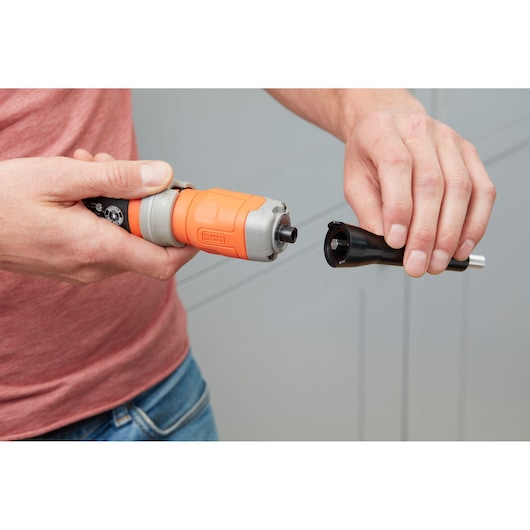 Photo of BLACK+DECKER BCF603C screwdriver held by a person, attaching a black accessory, close-up.