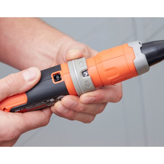 Photo of a person holding a BLACK+DECKER BCF603C cordless screwdriver, showing the orange and black grip and control buttons.