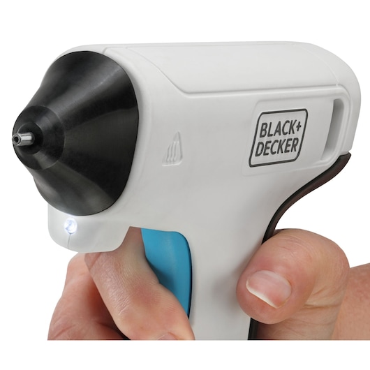 BLACK+DECKER BCGL115 white cordless glue gun side angle with LED light, held in hand.