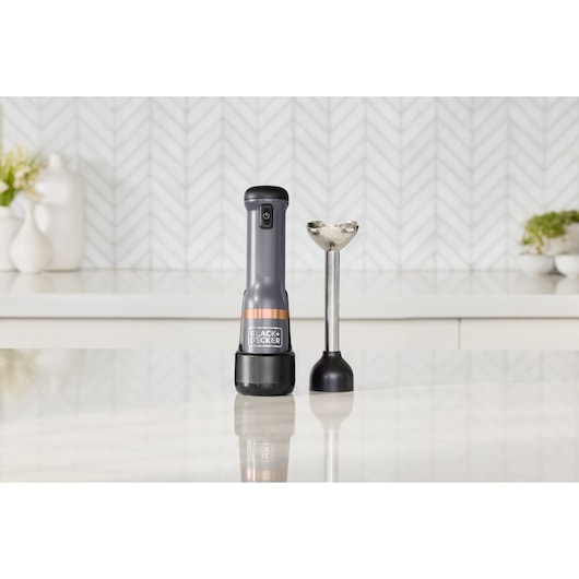 Photo of BLACK+DECKER hand blender BCKM1011KGF with metallic shaft and black handle, shown on kitchen counter.
