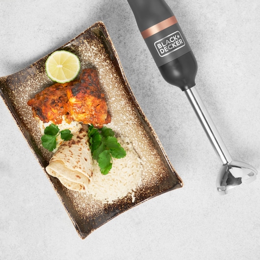 Photo of BLACK+DECKER BCKM1011KGF hand blender with a plate of rice, grilled chicken, flatbread, lime, and cilantro on the side.