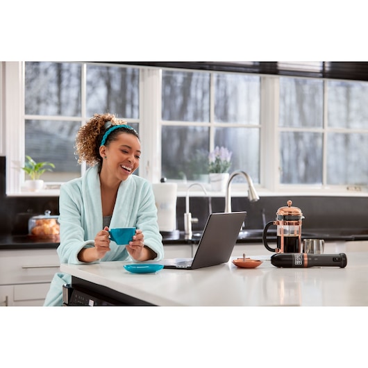 Photo of BLACKDECKER BCKM1011KGF hand mixer on kitchen counter near laptop, coffee press, and coffee cup.