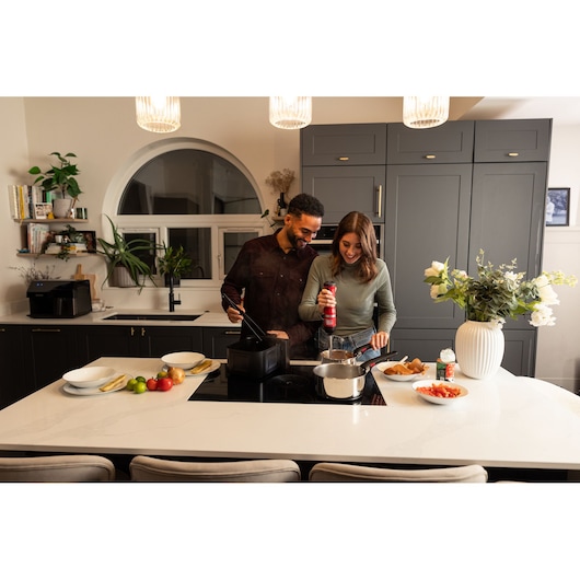 BLACKDECKER BCKM1012KR kitchen appliance on countertop with couple cooking in modern kitchen setting.