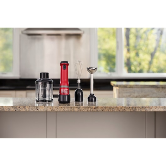 BLACKDECKER BCKM1013KR hand blender set with red and black base, whisk, chopper, and blending attachment on kitchen counter.