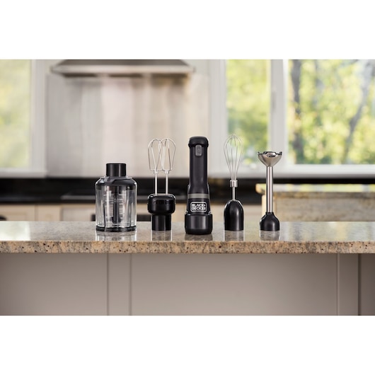 BLACKDECKER BCKM1014KB black hand mixer set with attachments including beaters, whisk, chopper, and blending shaft on kitchen counter.