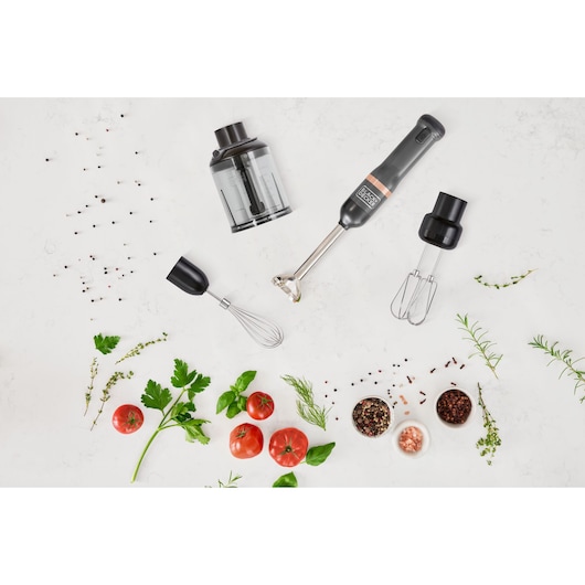 BLACKDECKER BCKM1014KG hand blender set with whisk, chopper, and beaters on a white surface with herbs and tomatoes.