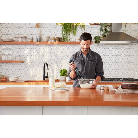 BLACKDECKER BCKM1016KSB hand mixer used in modern kitchen near bowl and baked goods.
