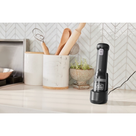 BLACK+DECKER BCKM1016KSB black immersion blender upright on kitchen counter near utensils.