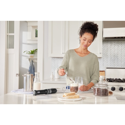 Photo of BLACKDECKER BCKM1016KSB handheld milk frother on kitchen counter with coffee and bread.