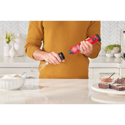 Photo of BLACKDECKER BCKM1016KSR cordless mixer in red being assembled in a modern kitchen setting.