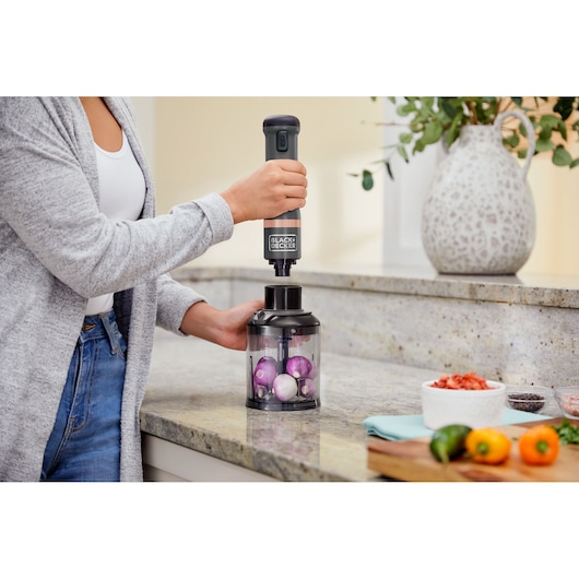 Photo of BLACK+DECKER BCKM101FP food chopper in use on a kitchen counter with onions inside the container.
