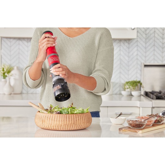 Photo of BLACKDECKER BCKM101SPFF electric pepper grinder being used over a salad bowl in a modern kitchen.