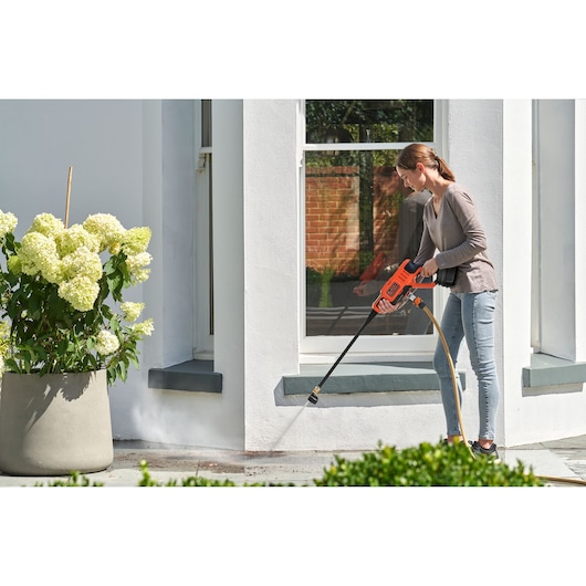 Photo of BLACKDECKER BCPC18B pressure washer cleaning outdoor pavement by a white house.