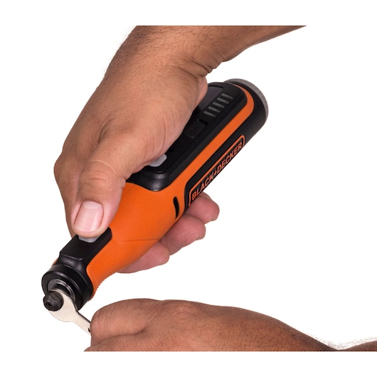 Photo of BLACKDECKER BCRT8I orange cordless rotary tool held in hand, side angle, tool in use.