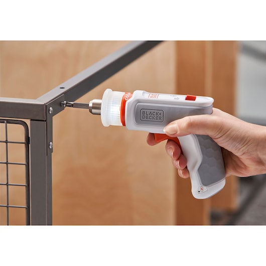 Photo of BLACKDECKER BCRTA01 cordless screwdriver with LED light used to fasten screw on metal frame.