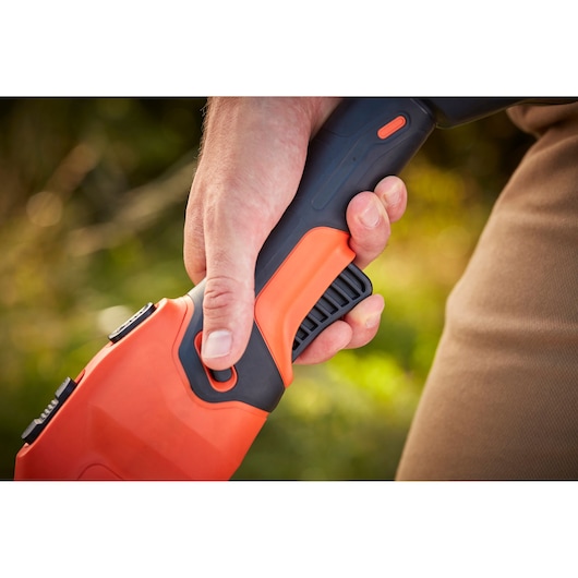 Close-up photo of BLACK+DECKER BCSTE636L1 garden tool handle with black and orange grip being held by a hand.