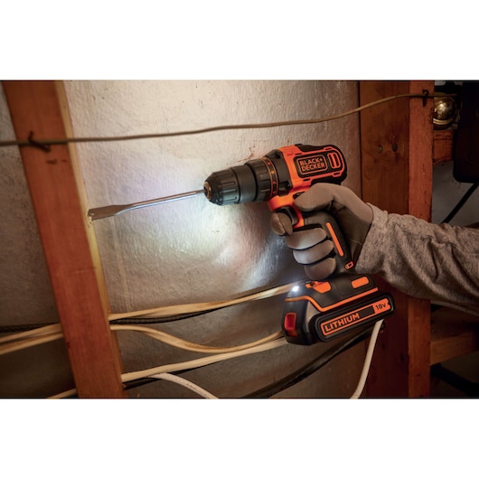 BLACKDECKER BDCDD186K cordless drill in use, 18V lithium-ion, photographed during wall installation.