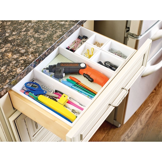 Photo of BLACK+DECKER BDCSFL20C cordless screwdriver in an organized kitchen drawer with office supplies.