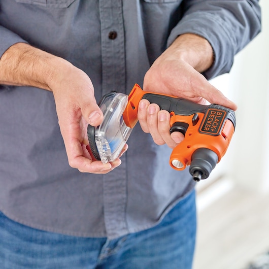 Photo of BLACK+DECKER BDCSFS30C cordless screwdriver held in hand, with accessory case, close-up view.