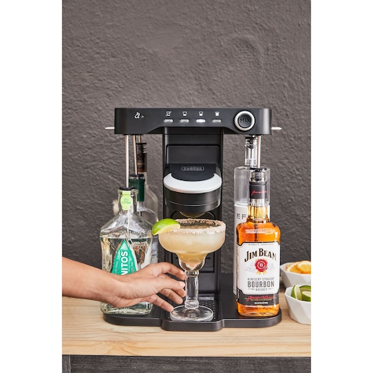 BLACKDECKER BEHB101 cocktail maker front view, surrounded by liquor bottles and a margarita glass.