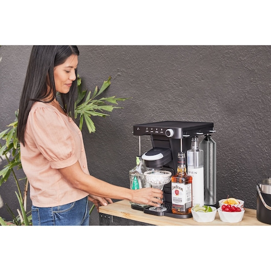 BLACKDECKER BEHB101 beverage machine on countertop with bottles and garnishes, side angle view.
