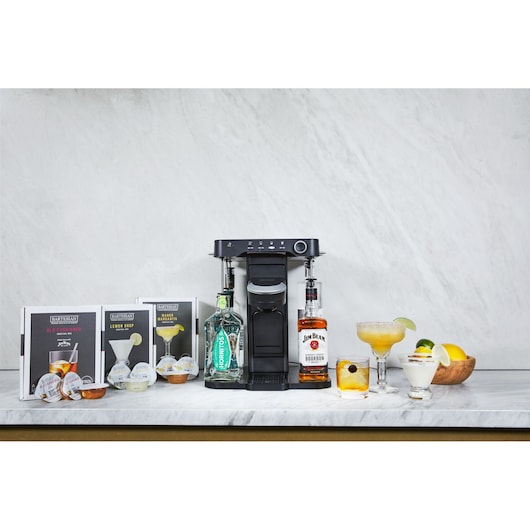 BLACKDECKER BEHB101 cocktail maker with liquor bottles, cocktail pods, and mixed drinks on a marble counter, front angle.