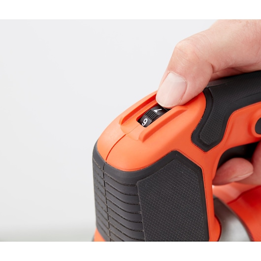 Close-up of BLACKDECKER BES610K hand grip and speed dial, orange and black, user adjusting setting.