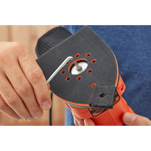 BLACKDECKER BEW200K sander close-up, pad being adjusted with hex key, orange and black body.