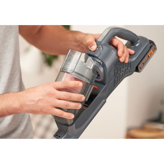 Photo of BLACKDECKER BHFEA18D1 cordless vacuum cleaner dust container being removed by hand.
