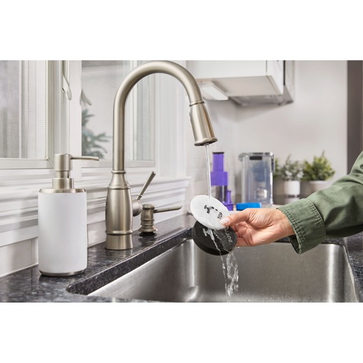 BLACKDECKER BHFEA640WP cleaning pads being rinsed under kitchen faucet in photography product category.