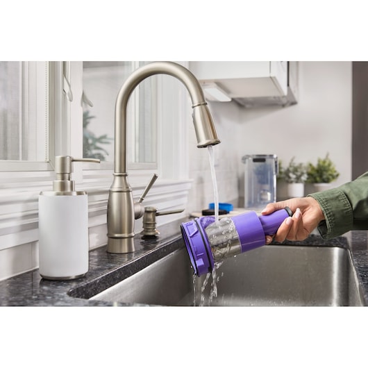 BLACKDECKER BHFEA640WP vacuum filter being rinsed under kitchen faucet, product photography.