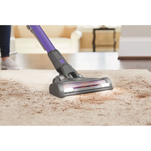 BLACKDECKER BHFEV182CP cordless vacuum cleaning dirt from carpet in living room, close-up angle.