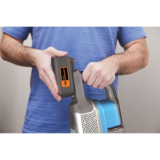 BLACK+DECKER BHFEV362D vacuum cleaner close-up with a person attaching the removable 36V lithium battery.
