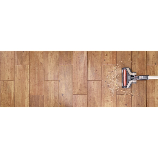 BLACKDECKER BHFEV36B2DW cordless vacuum cleaning debris on wooden floor, top view.