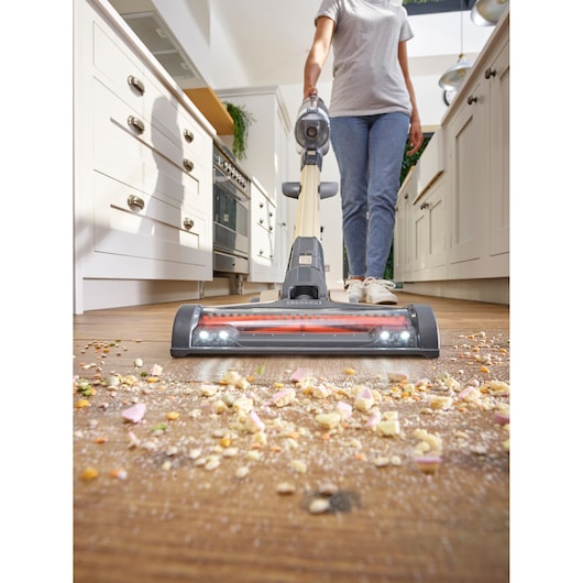 BLACKDECKER BHFEV36B2DW cordless stick vacuum cleaning crumbs in a kitchen, front angle.
