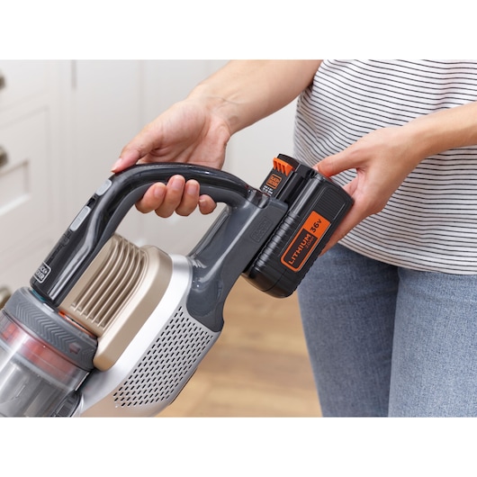 BLACKDECKER BHFEV36B2DW cordless vacuum with 36V lithium battery held in hand, side angle.