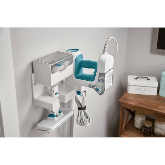 BLACKDECKER BHSM15FX10 steam mop with detachable water tank in white and teal on wall-mounted holder, angled view.