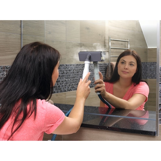 BLACKDECKER BHSM1615DSG steam cleaner used to clean bathroom mirror, product in hand, photography.