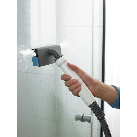 BLACKDECKER BHSM1615DSG steam cleaner attachment cleaning glass shower door, close-up view.