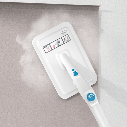 BLACKDECKER BHSMP2314 steam mop cleaning a gray wall, close-up of mop head, white and blue design.