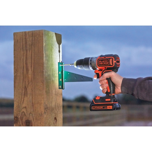 BLACKDECKER cordless drill BL188N used to attach bracket to wooden post outdoors.