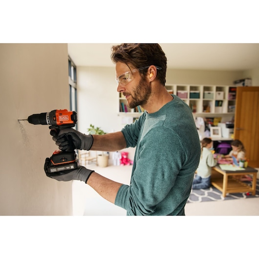BLACKDECKER cordless drill BLD683D1 in use indoors, person wearing gloves drilling into a wall.
