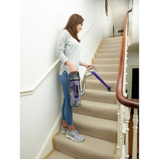 BLACKDECKER CUA625BHP vacuum cleaner with purple accents used on carpeted stairs.