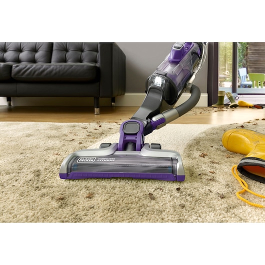 BLACKDECKER CUA625BHP cordless lithium vacuum cleaning beige carpet in living room, low-angle photography.