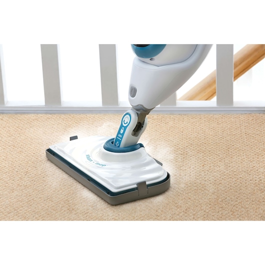 BLACKDECKER FSMCG steam mop cleaning beige carpet, close-up angle.