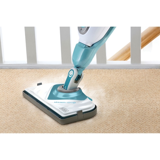 BLACKDECKER FSMCG steam mop cleaning beige carpet, photo from above showing mop head and handle.