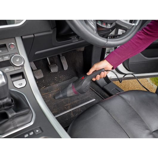 BLACKDECKER NVB12AV handheld vacuum cleaning car floor mat by pedals.